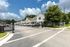 Charming townhouse community featuring modern architecture, ample parking, and lush greenery under a bright blue sky.