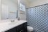 Modern bathroom featuring a sleek vanity, large mirror, and stylish blue geometric shower curtain.