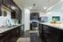 Modern kitchen with sleek dark wood cabinets, stainless steel appliances, and a stylish marble island, perfect for culinary enthusiasts.