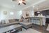 Inviting open-plan living space with a comfy sectional sofa, modern kitchen with bar seating, and elegant pendant lighting.