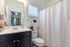 Bright, modern bathroom with sleek vanity, elegant fixtures, and a stylish shower curtain.