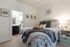 Inviting bedroom with cozy bed, stylish decor, and attached bathroom, perfect for peaceful relaxation.