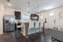Modern kitchen with sleek stainless steel appliances, elegant island seating, and chic pendant lighting for a cozy dining experience.