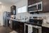 Modern kitchen with sleek appliances, dark wood cabinets, and granite countertops, offering a stylish and functional culinary space.