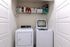 Modern laundry area equipped with state-of-the-art washer and dryer, complete with overhead storage shelf, ideal for efficient living.