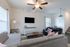 Inviting living room with modern sofas, mounted TV, and plush decor in a bright, airy space.