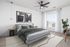 Elegant bedroom with modern decor, featuring a plush bed, stylish artwork, and ample natural light from a large window.