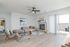 Bright and modern living room with a cozy sectional sofa, stylish fireplace, and sliding glass doors opening to a balcony.