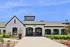 Charming leasing office with classic architecture, vibrant landscaping, and welcoming atmosphere at property entrance.