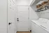 Modern laundry room with sleek appliances, ample shelving, and organized storage in a stylish apartment.