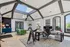 Elegant office space with vaulted ceilings, skylights, modern decor, and a welcoming seating area.