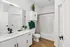 Elegant bathroom featuring a modern sink, sleek black fixtures, and minimalist cabinetry with vibrant plants for a refreshing touch.