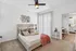 Inviting bedroom with modern furnishings, plush pillows, and warm natural light, connected to a cozy dining and kitchen area.