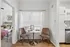 Charming dining nook with elegant round table and stylish chairs, adjacent to a cozy bedroom and modern kitchen.