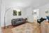 Cozy living room with stylish decor, featuring a modern gray sofa, elegant floor lamp, and vibrant wall art, creating a welcoming atmosphere.