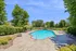 Luxurious outdoor pool surrounded by lush greenery and comfortable lounge chairs, perfect for relaxation and leisure.