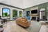 Bright and inviting living room with large windows showcasing a beautiful outdoor view, stylish modern furnishings, and a cozy fireplace.
