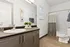 Modern bathroom with sleek vanity, decorative plants, ample mirror, and stylish artwork.