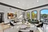 Bright and inviting living space with modern kitchen, plush seating, and scenic poolside view through large windows.