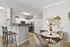 Chic apartment interior showcasing a stylish kitchen with modern appliances, cozy dining area with elegant decor, and inviting seating at bar counter.