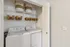 Chic in-unit laundry space featuring modern washer and dryer with stylish woven baskets for organized storage.