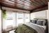 Cozy bedroom with rustic wood ceiling, large windows with curtains, and elegant green bedding.