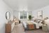 Bright, modern bedroom with a cozy double bed, stylish furnishings, and a large window inviting natural light.