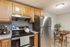 Charming kitchen with stainless steel appliances, sleek wooden cabinets, and a cozy dining nook perfect for intimate meals.