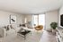 Elegant living room with modern decor, featuring a cozy beige sectional sofa, chic black coffee table, and stylish mustard armchair. Natural light pours through glass sliding doors, accompanied by lush greenery and minimalist artwork.