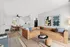 Chic living space featuring a stylish sectional sofa, modern art, and a cozy dining area with a sleek ceiling fan, perfect for contemporary living.