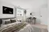 Bright and inviting bedroom with cozy bedding, modern decor, and a stylish workspace by the window.