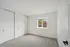 Bright, cozy bedroom with fresh carpeting, a large window offering serene neighborhood views, and ample closet space.