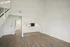 Modern open-plan apartment with elegant wooden flooring, high ceilings, and a chic kitchen.