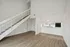 Bright, modern apartment with sleek wooden floors, a charming staircase, and a open kitchen view.