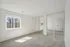 Bright and spacious room with plush carpet, large window, and sleek mirrored sliding closet doors.