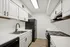 Chic modern kitchen with sleek black appliances, white cabinetry, and elegant wood flooring.