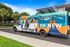 Vibrant shuttle bus at reNEW Tallahassee with colorful graphics and sunny backdrop, promoting premier student living.