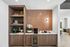 Chic kitchenette with elegant open shelving, patterned backsplash, and a mini fridge; perfect blend of style and functionality.
