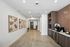 Elegant hallway with modern decor, featuring floral artwork, a stylish beverage station, and ambient lighting, creating a welcoming atmosphere.