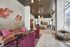 Chic and inviting living space featuring modern furniture, artistic wall decor, and ample natural light.