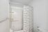 Bright and modern bathroom with a sleek bathtub, stylish shower curtain, and elegant fixtures.
