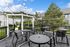 Charming outdoor deck with elegant string lights, cozy seating, and lush greenery for a serene atmosphere.