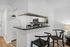Modern kitchen with sleek black countertops, bar seating, and elegant white cabinetry, highlighting open and stylish living space.