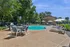 Inviting outdoor pool area with stylish lounge chairs, umbrellas, and lush green surroundings for a perfect relaxing retreat.