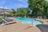 Inviting outdoor pool area with stylish lounge chairs and umbrellas, surrounded by lush greenery.