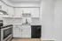 Modern kitchen with sleek white cabinetry, stainless steel appliances, and elegant countertops.