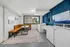 Modern shared laundry room with bright seating area and large windows, featuring top-quality washers and a stylish bench setup, perfect for convenience and relaxation during chores.