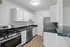Modern kitchen with sleek stainless steel appliances, elegant black countertops, and pristine white cabinetry, offering a stylish and functional cooking space.
