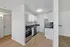 Modern kitchen with sleek appliances, white cabinetry, and elegant hardwood flooring, perfect for contemporary living.
