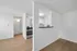 Bright and modern apartment featuring a sleek kitchen with stainless steel appliances and elegant hardwood flooring.